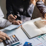 Stressed young couple checking bills, taxes, bank account balance and calculating expenses in the living room at home